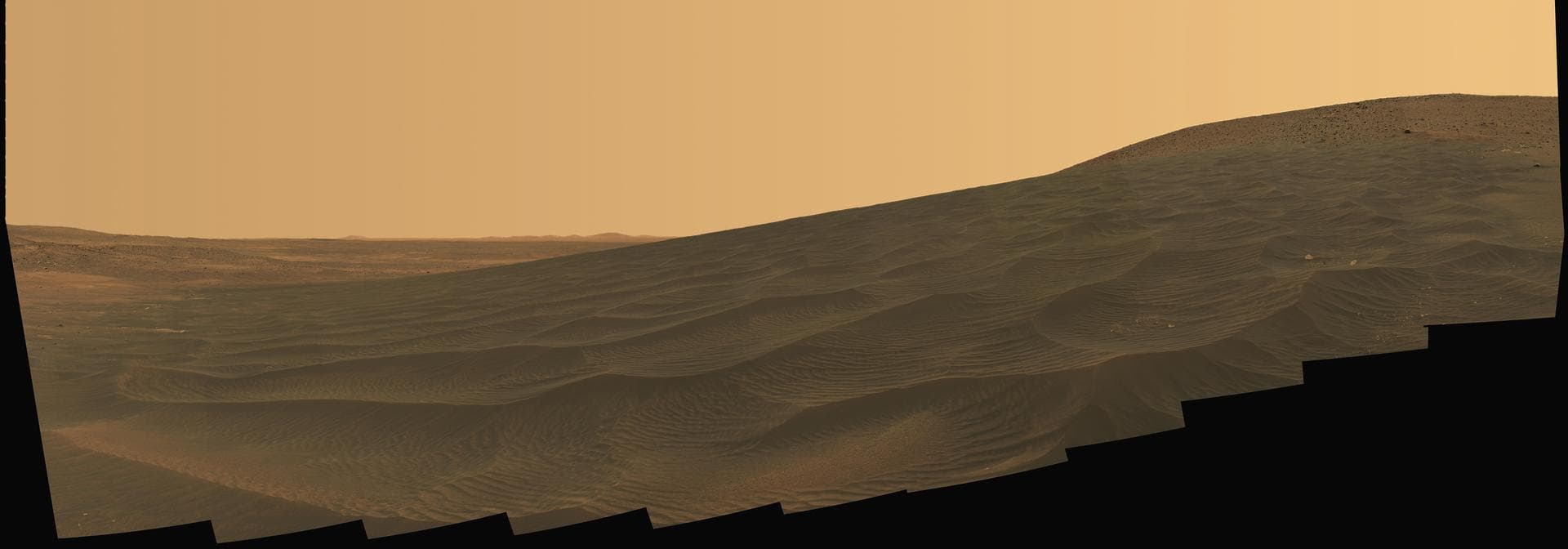 Spirit surveys intricately rippled sand deposits from the rover's distant, rust-colored world.