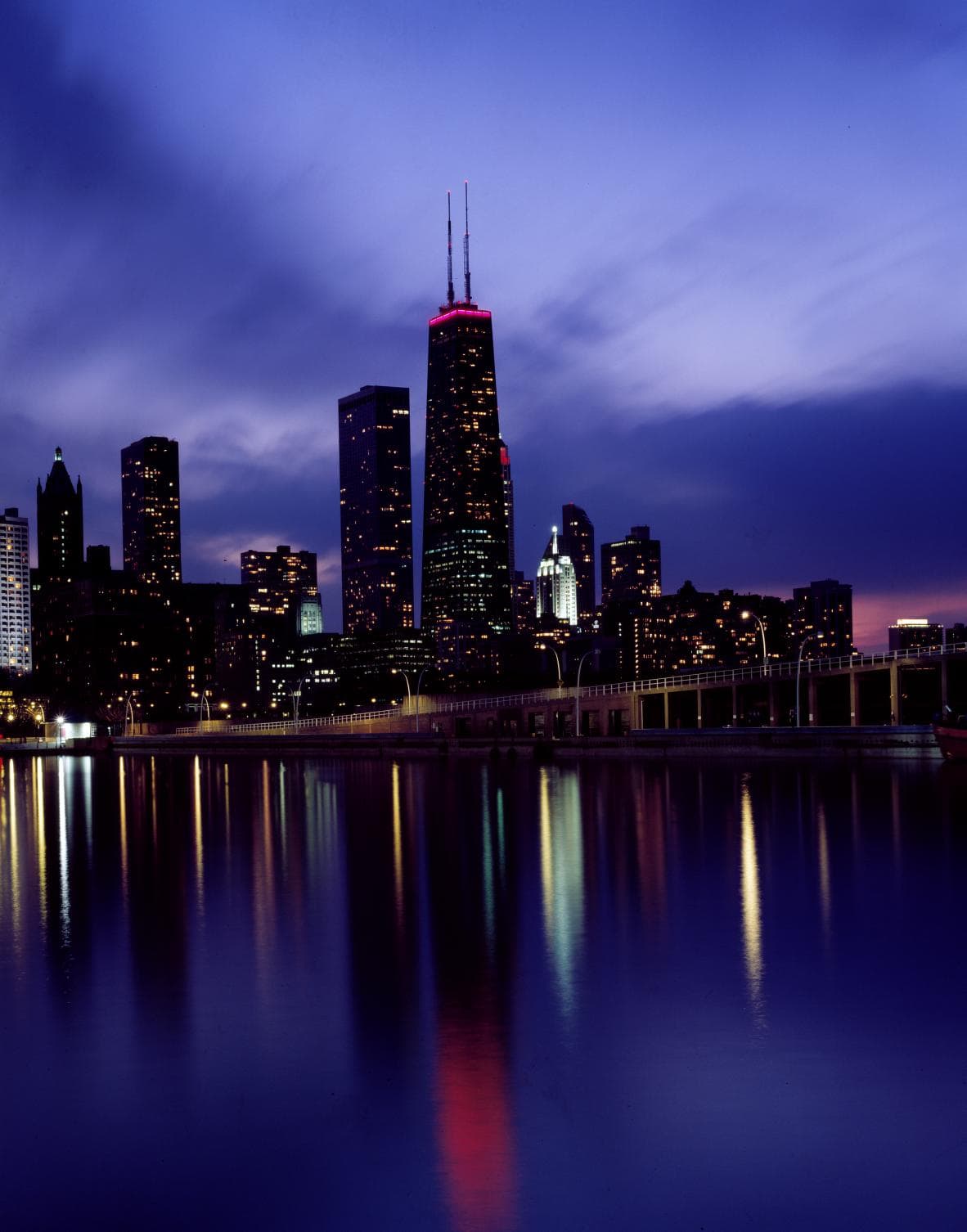 The skyline glows beneath Sears Tower as office lights take over from daylight.